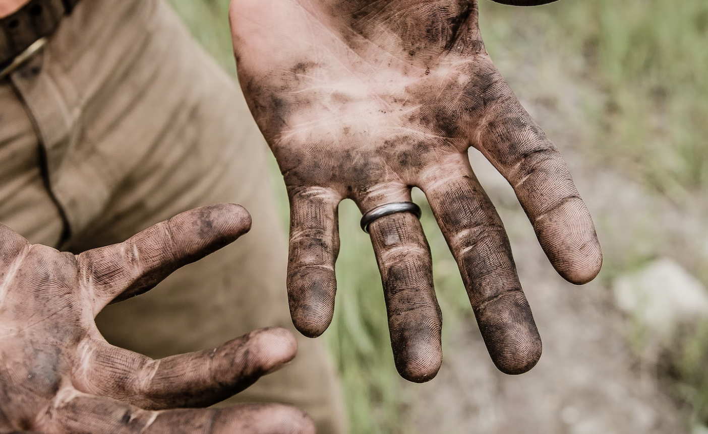 Photo of a man with a wedding ring having dirty hands