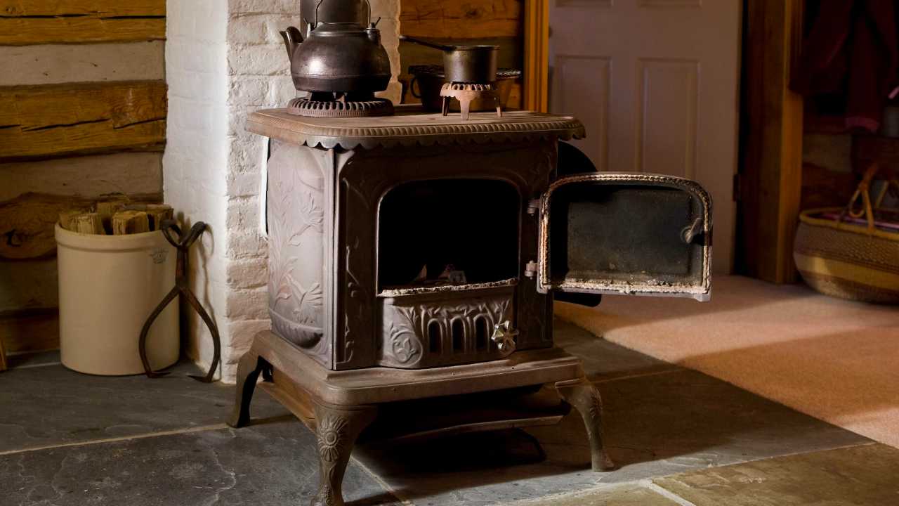 Photo of a log burner with the door open on a tiles floor