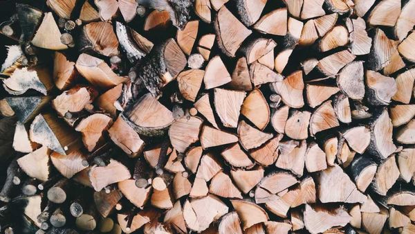 Photo of split logs all stacked ready to be used for burning